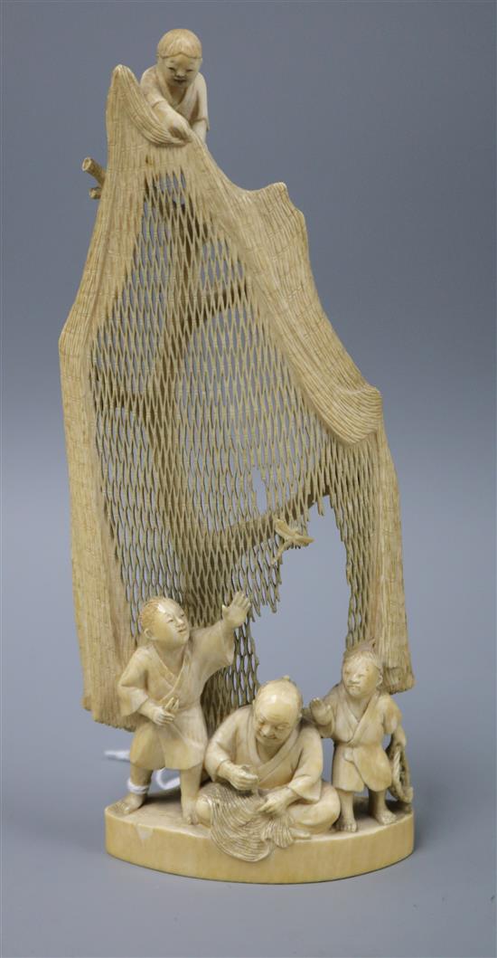 A Japanese ivory okimono of a fishermen mending a net